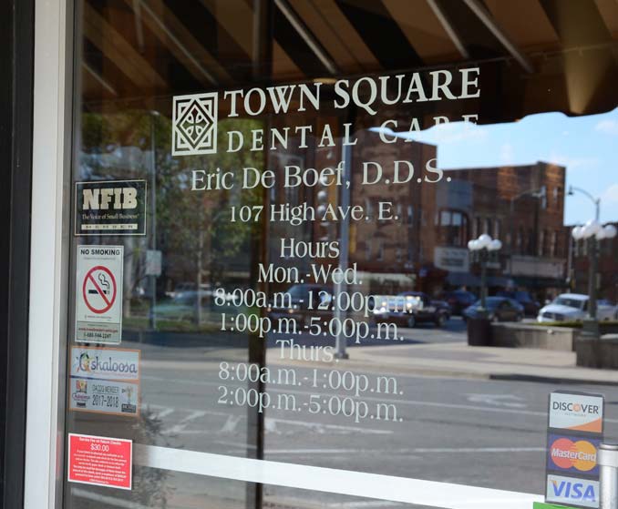 Exterior of Town Square Dental Care with signage for business hours in Oskaloosa, IA